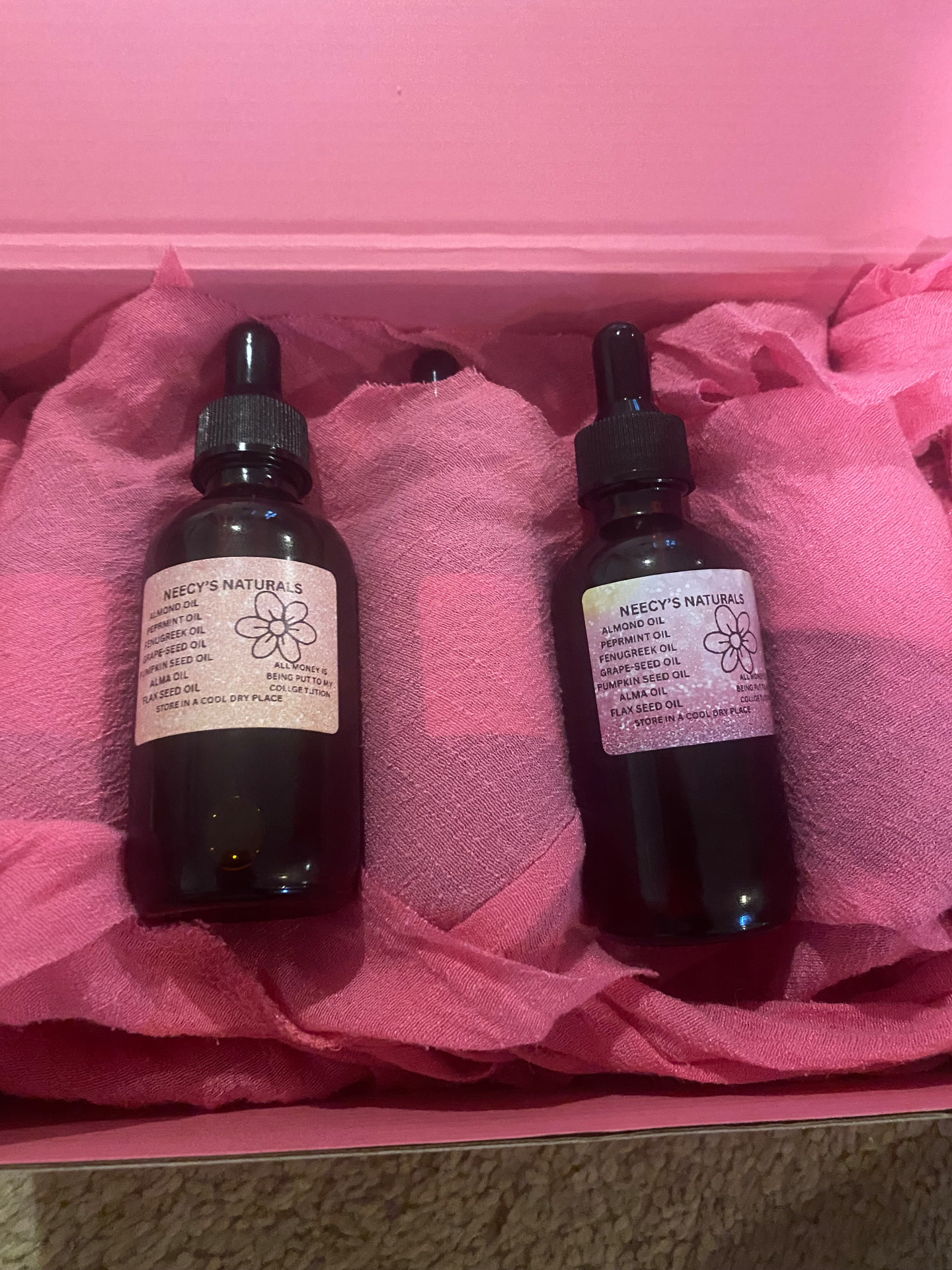 Neecy's Naturals hair growth oil bottles in a pink gift box